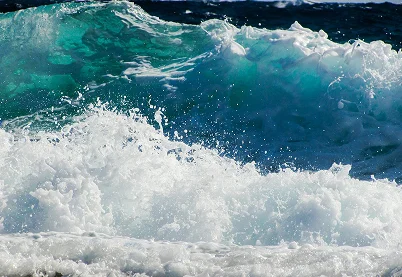Cresting turquoise ocean waves with white sea foam representing emotional turbulence and anxiety