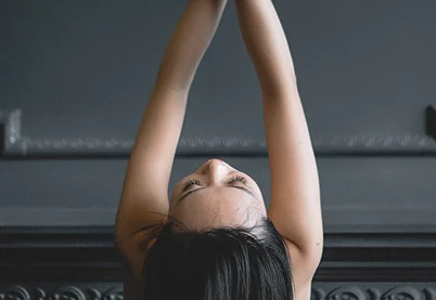 Woman with arms raised and eyes closed in a moment of release, representing depression recovery and mental wellness.