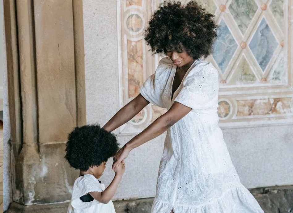 Mother and child holding hands and smiling indoors