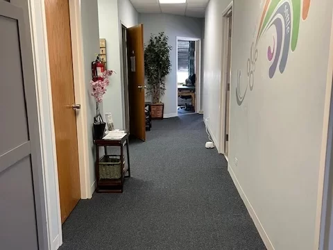 A decorative 'Be Present' sign next to a small succulent on a white shelf, reflecting our office environment and mindful approach.